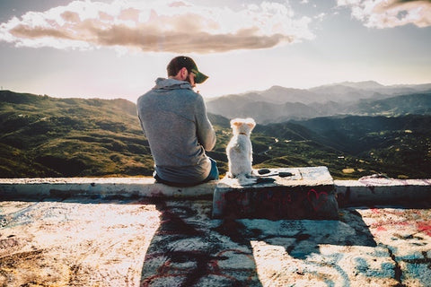 A man sitting down with his dog