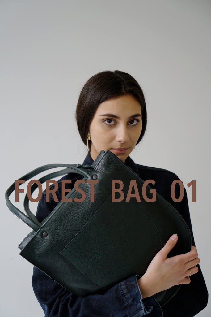 female model wearing a green Horween leather tote bag