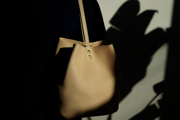 Female model in the sun wearing a leather backpack