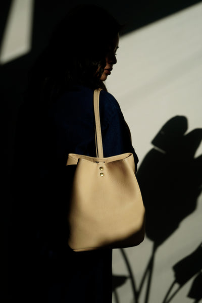 Female model in the sun wearing a leather backpack