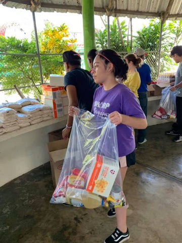 Volunteer Holding Bag Of Donations