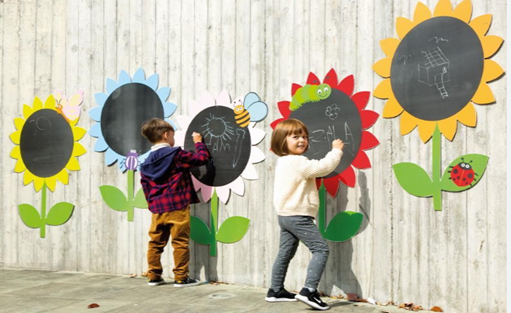 Children drawing outside on chalkboard flowers