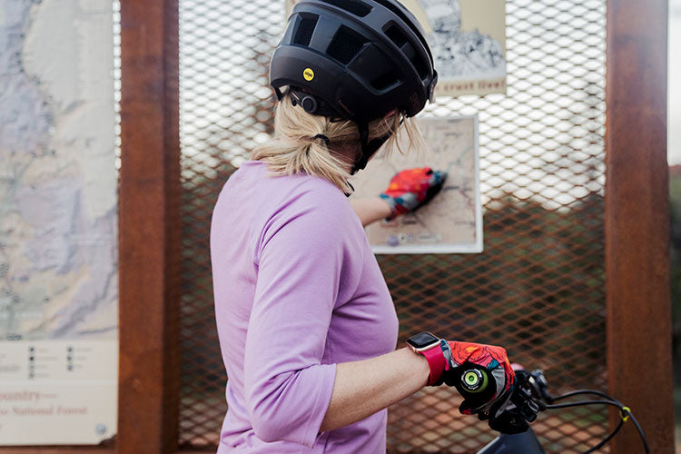 Woman mountain biker reading map at trailhead