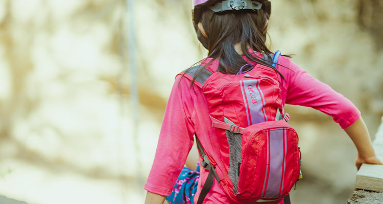 Young girl wearing water carrying backpack