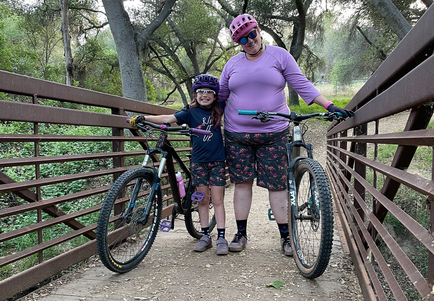 Mother and daughter wearing matching dinosaur mountain biking shorts