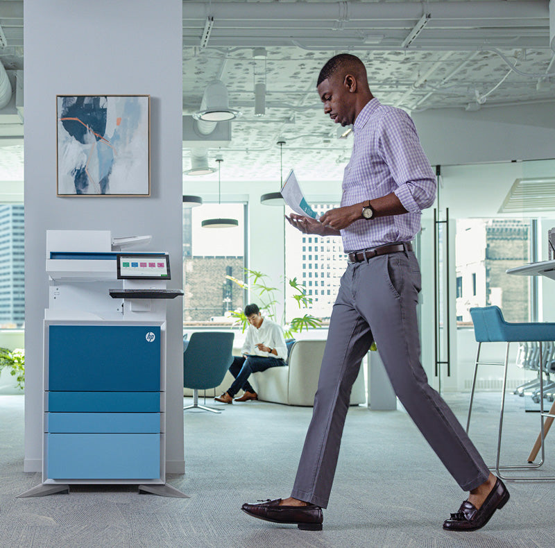 Man in office walking past HP E700/E800 series printer