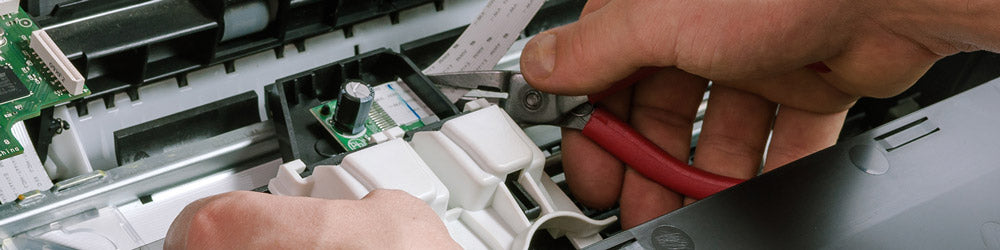 Image showcasing a man performing maintenance on an office printer