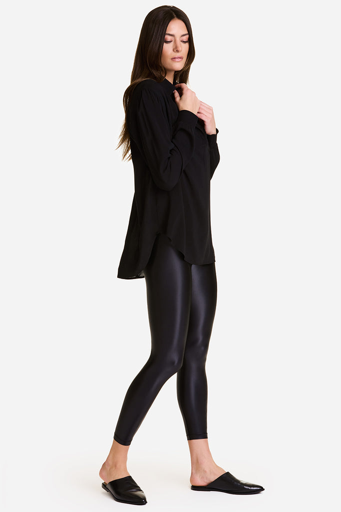 Woman wearing Alala Primary Tight in Liquid Black and Alala Diana Top in Black