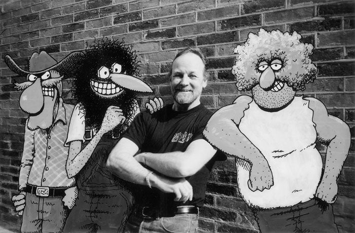 Gilbert Shelton standing with The Freak Brothers