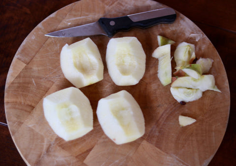 Quartered apple with all cores removed by a paring knife.