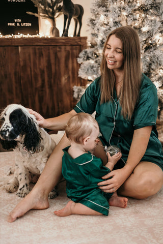 mummy and daughter wearing green christmas pyjams in front of christmas tree