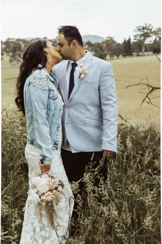 bride and groom kissing wearing pearl bride denim jacket