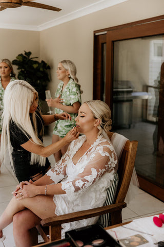 bride wearing envious dreams lace robe getting make up done