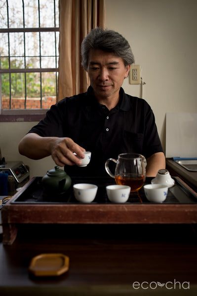Traditional charcoal-roasted Dong Ding Tea artisan, Mr. Su, serving tea in his home.