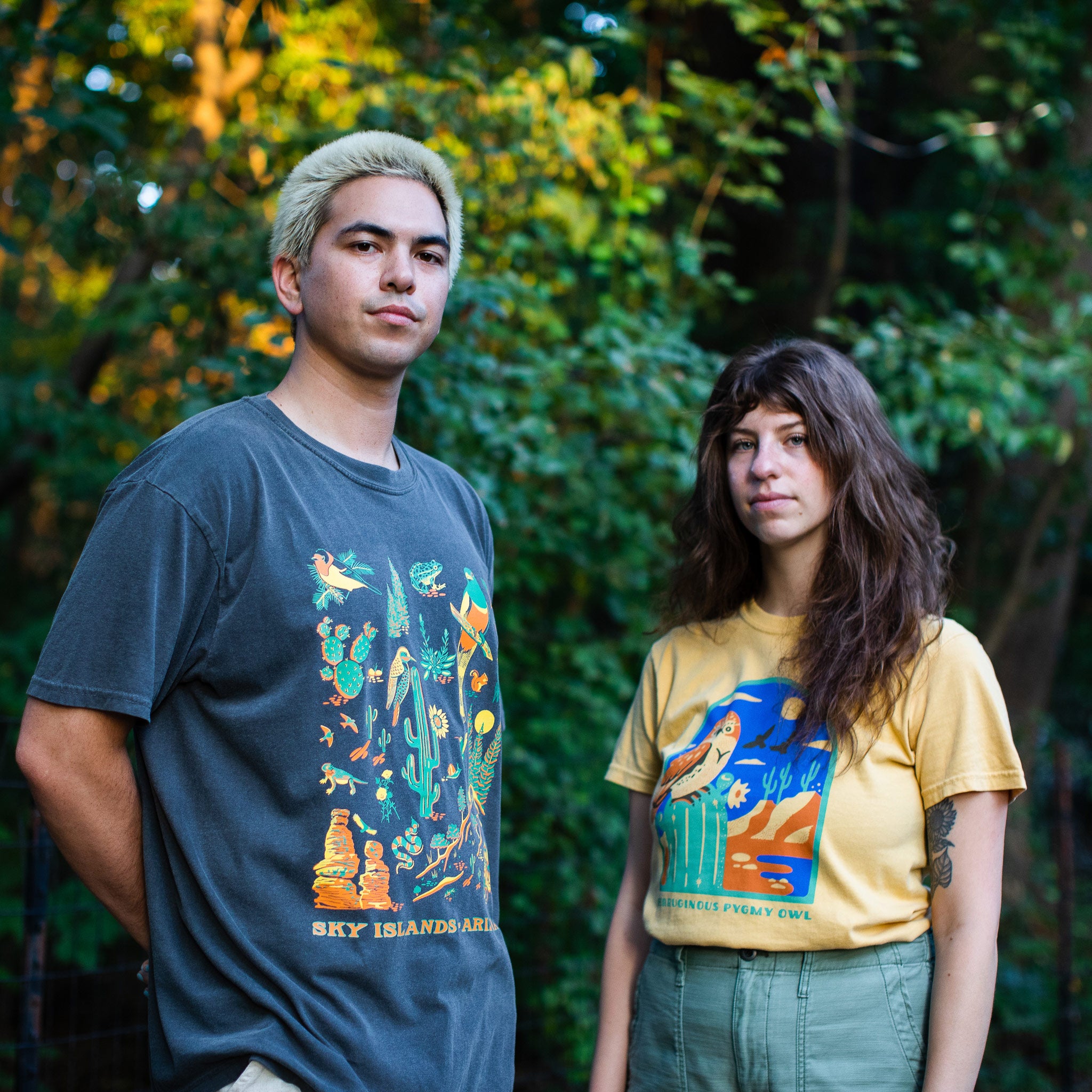 Photo of a man wearing a Sky Island, Arizona shirt and a woman wearing a shirt with an owl on a cactus