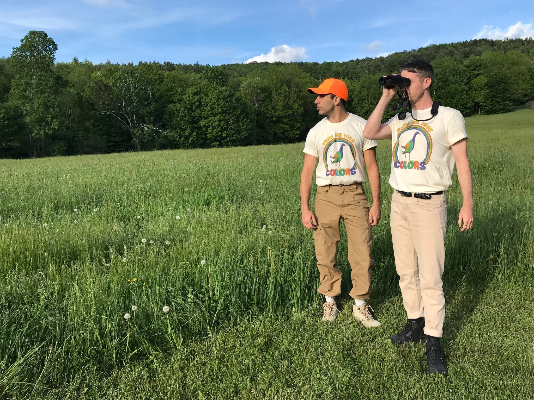 Birders in a green field wearing Bird Collective's Pride 2021 T-Shirt