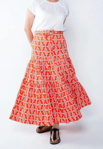 Model twirling in Nala Designs red tiered maxi skirt in crepe ginger flower print, available at The WYLD Shp