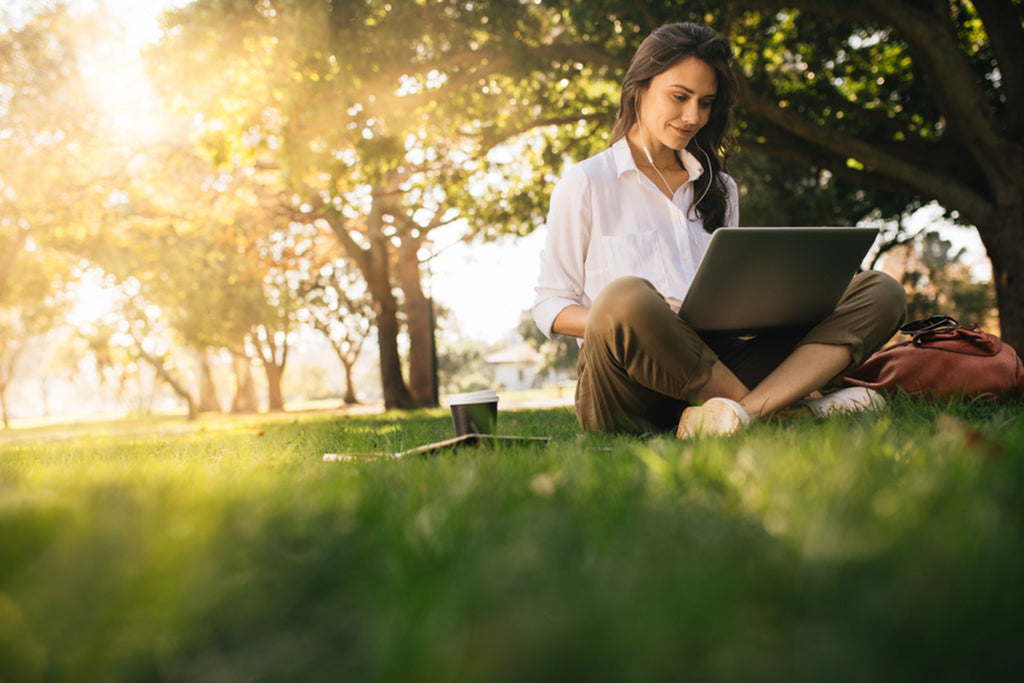 woman with laptop sitting outdside