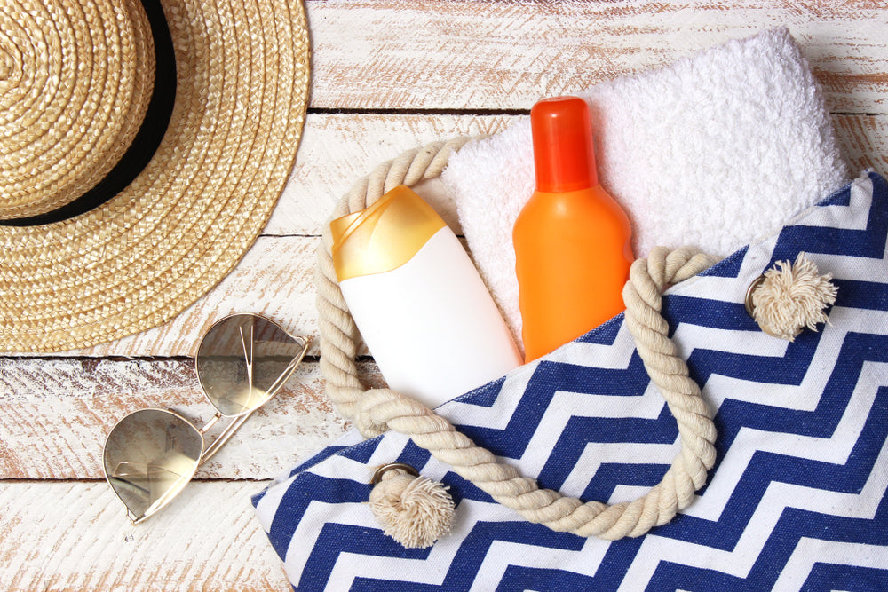 Broad-spectrum sunscreen and towel in a beach bag