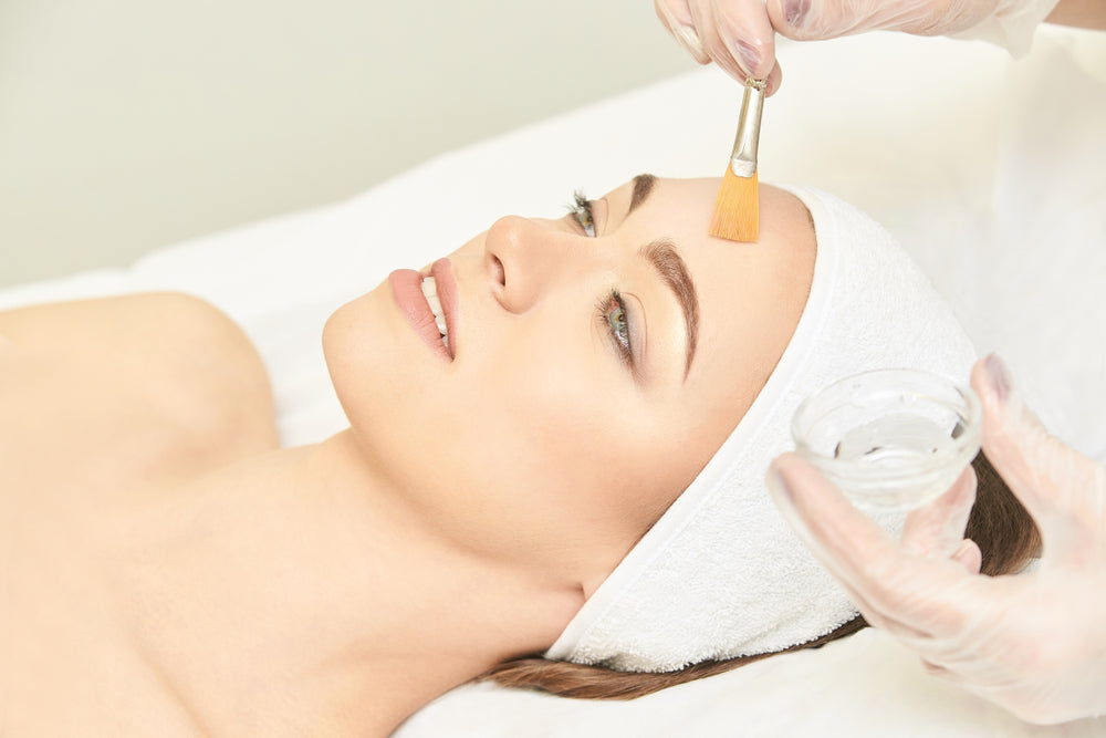 White woman laying on a spa bed receiving a facial.