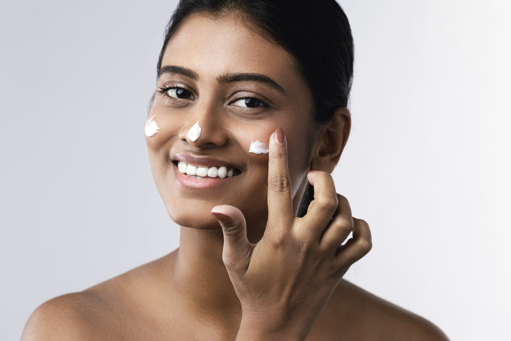 woman applying sunscreen to face