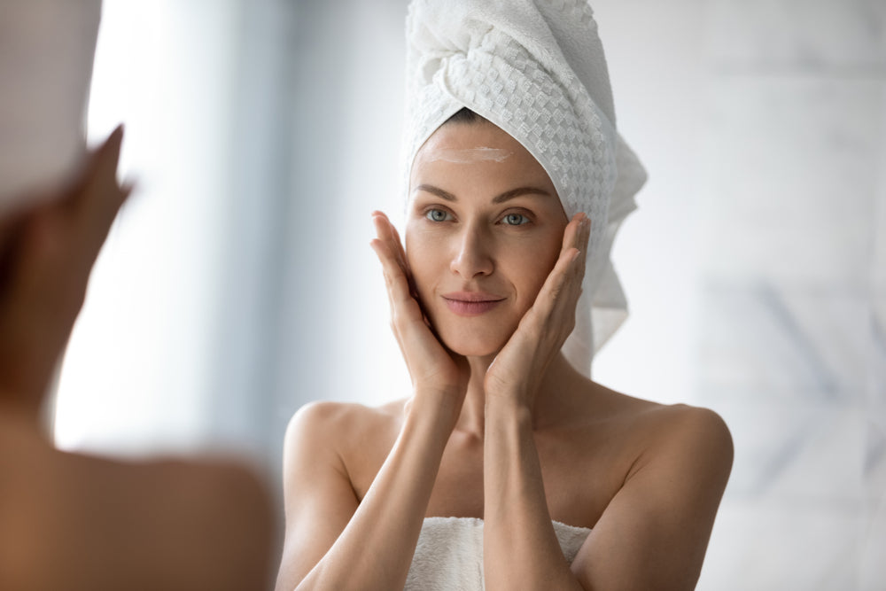 Woman applying acne treatment and prevention products after a shower