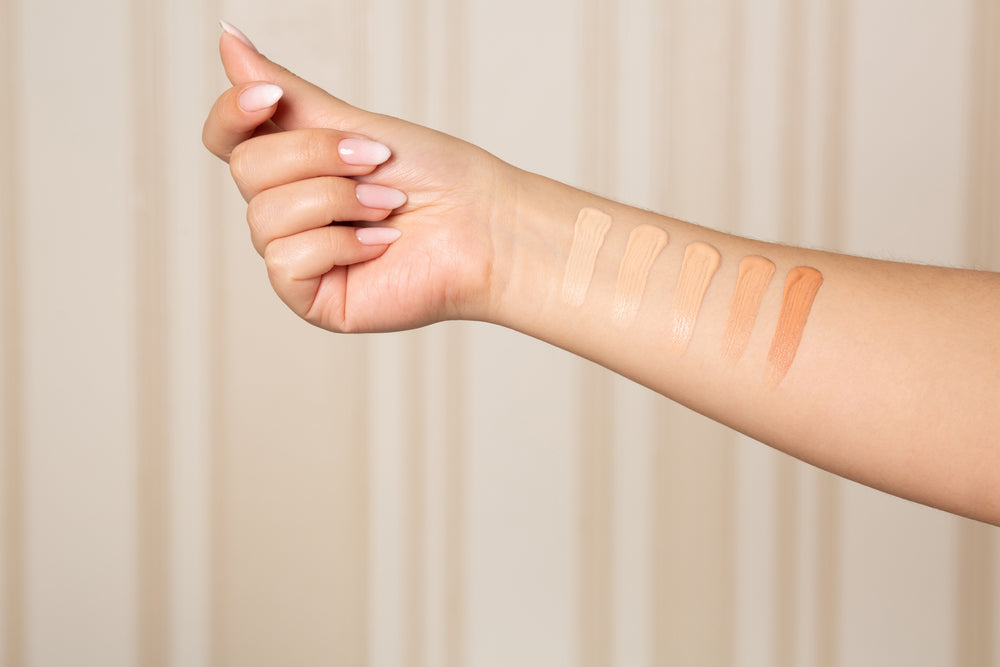 Image of several foundations swatched on a woman’s arm.