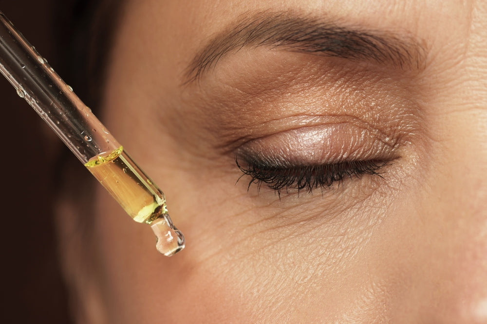 Close-up of a woman applying a serum to under-eye wrinkles.