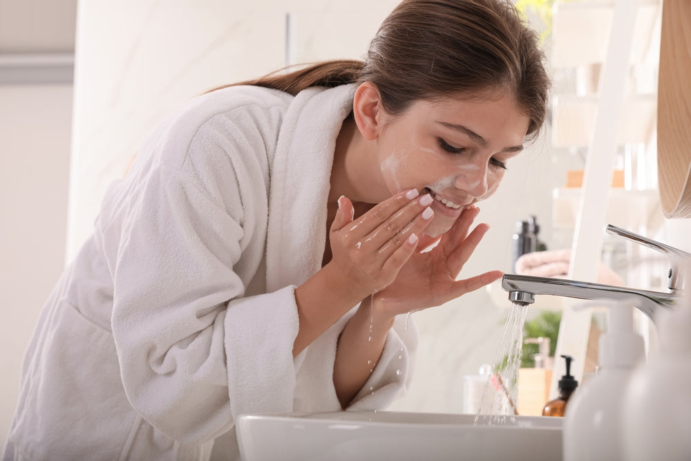 Teen girl washing her face.