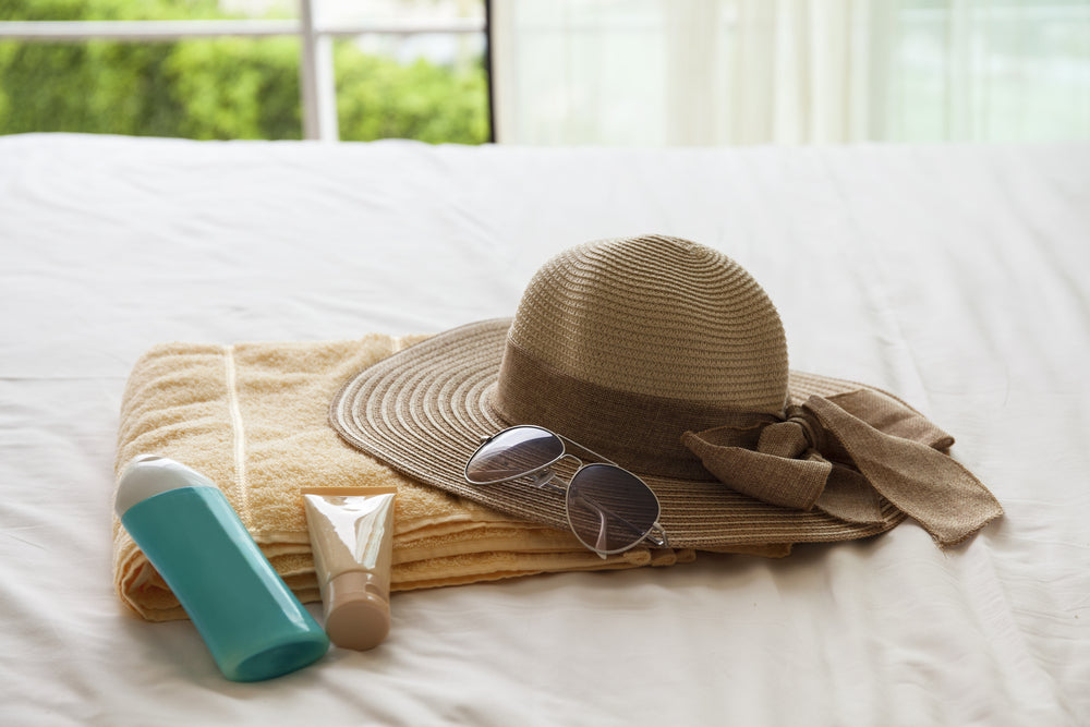 Sun protection items and towel on top of bed