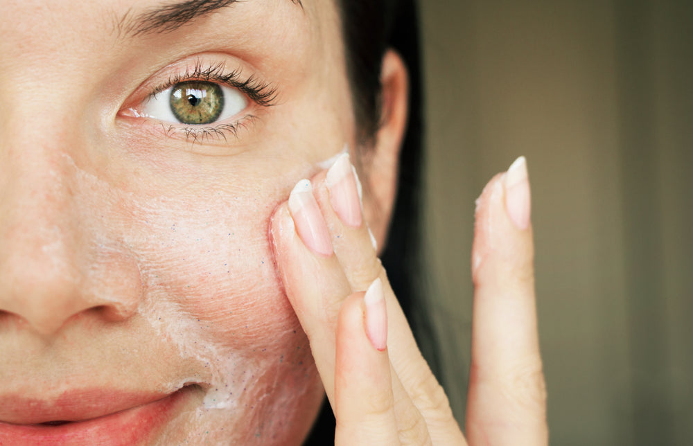 Lady applying gentle ingredient skin moisturizer to her face.