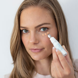 a woman applying Total Eye 3-in-1 renewal therapy