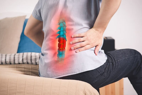 Image of a man holding his lower back in pain.