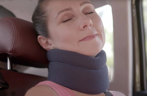 Image of a woman using the ComfyNeck neck brace while traveling.
