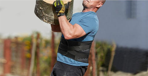 Image of a man carrying a log while wearing the OrthoRelieve LumbarPRO back brace.