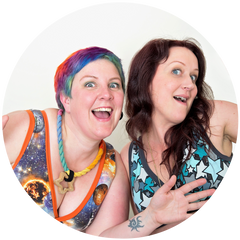 Kirsty and Ros looking happy in a circle. Kirsty has colourful short hair and is on the left. Ros has brown long hair and is on the right. Both women are wearing colourful Molke bras and are doing jazz hands.