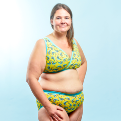 Model is wearing a blue tits print underwear set which is mostly yellow with illustrated blue tits.