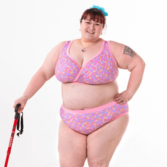 Rhona standing wearing a non-wired bra and high rise briefs in a pale pink knit pattern