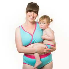 Model is wearing a blue and pink underwear set and holding a small child who is wearing matching children's pants.