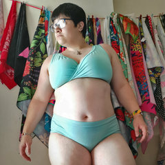 Model stands in her own home wearing the Skye underwear set. It is a light minty blue.
