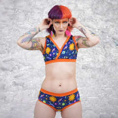 Model is wearing a Space underwear set with orange trim. She has half purple half orange hair.