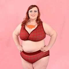 Model is wearing a red tartan underwear set with burgundy red trim.