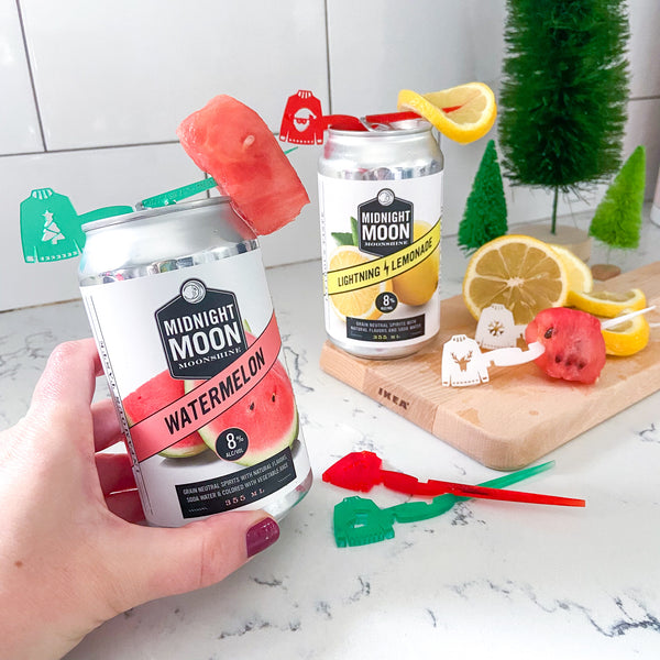 Midnight Moon Moonshine canned cocktails styled with Ugly Christmas Sweater drink markers for cans - Swizzly Sticks