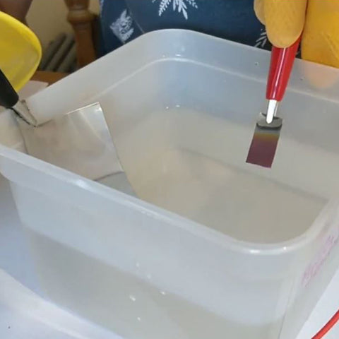 Silversmith Alice Fry anodising a piece of metal