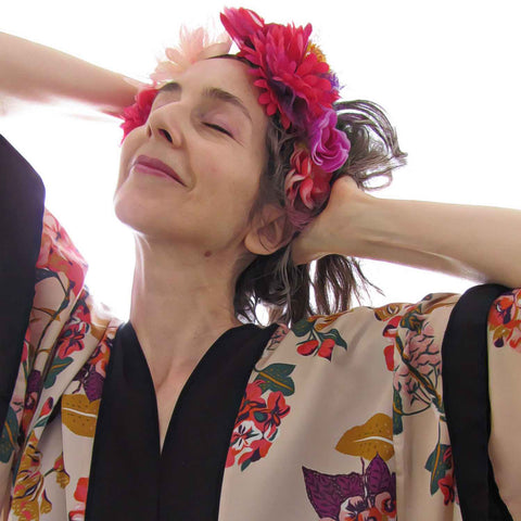 Alex Mitchell wearing floral kimono and flower crown feeling fab tilting head back smiling with eyes closed.