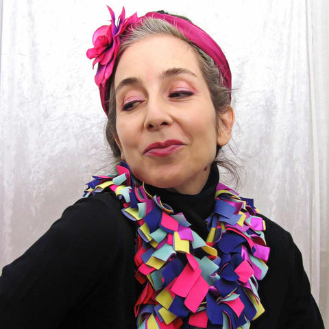 Alex Mitchell posing with a soft lush colorful boa scarf wrapped around the neck.