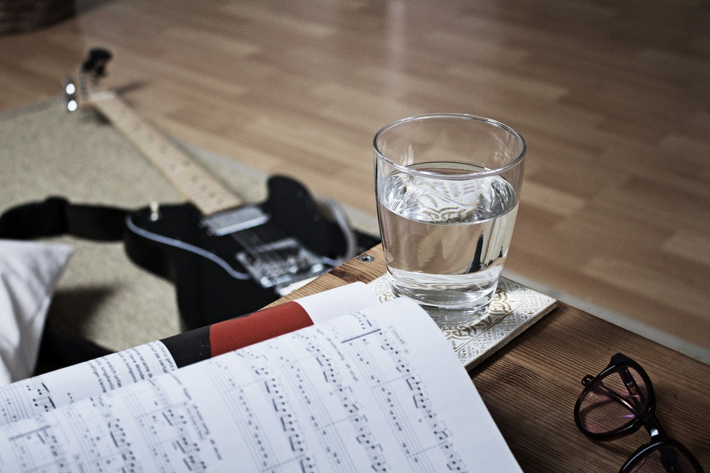 Guitarra y un vaso de agua.