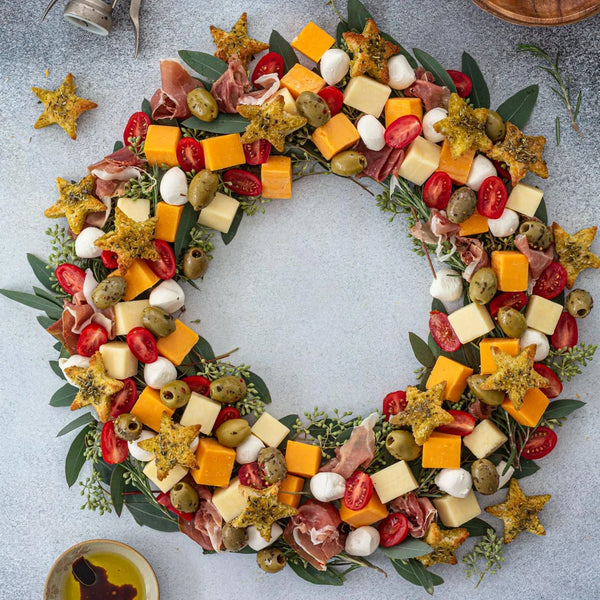 A selection of cheeses cubed and displayed in a circle with a Christmas wreath theme.