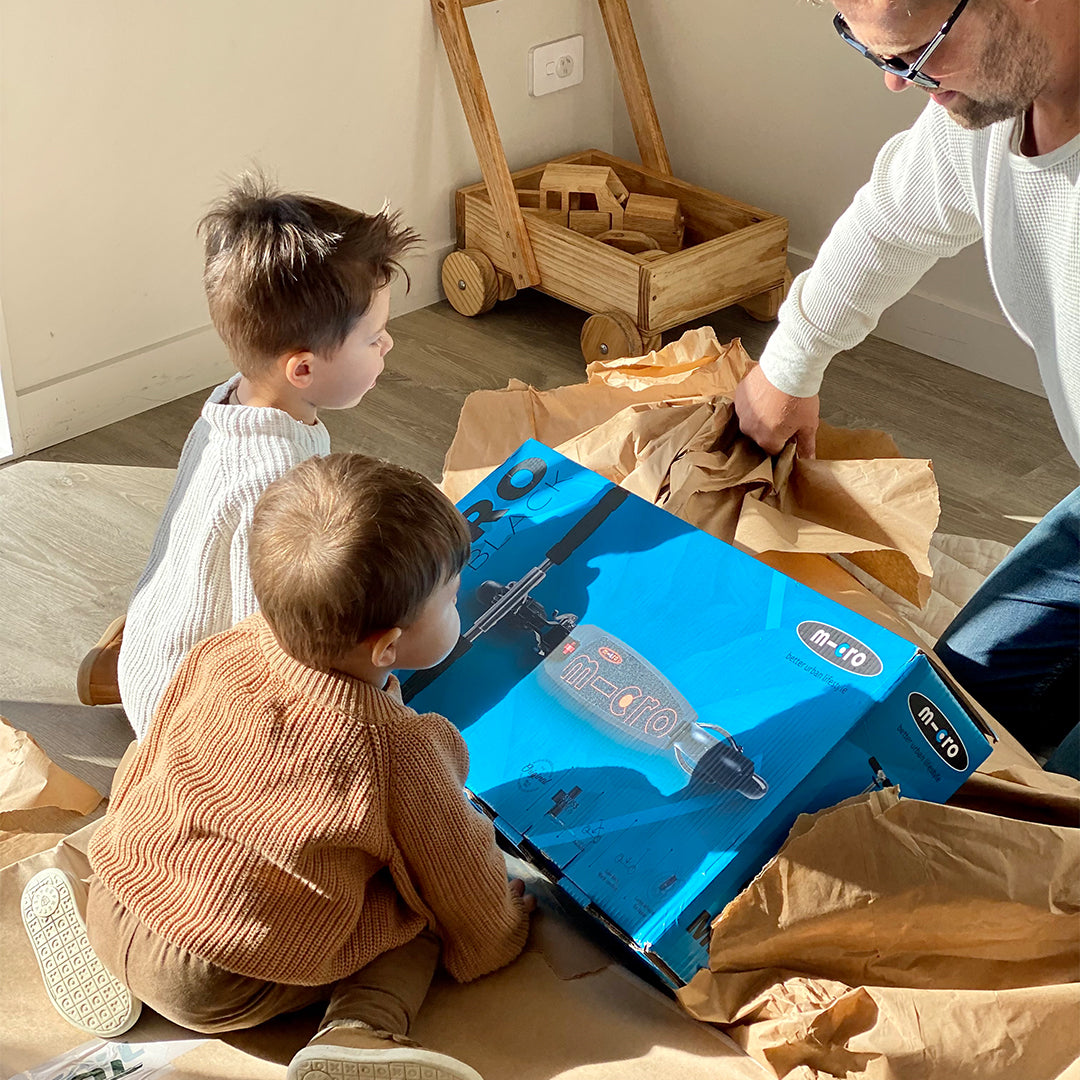 kids unwrapping christmas present with dad scooter