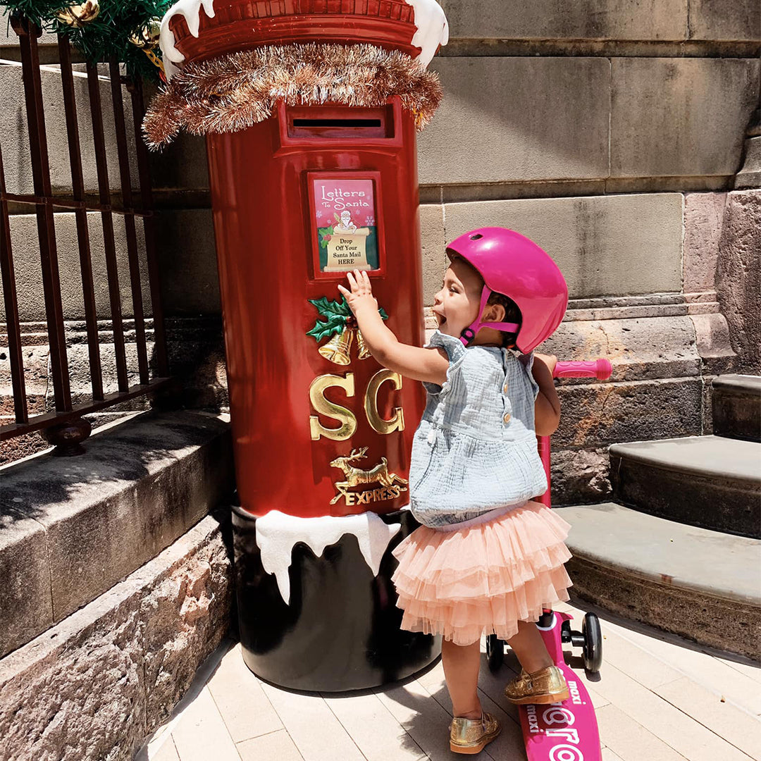 girl on 3 wheel micro scooter at santa post box